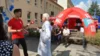 BB Radio Moderator und Chefarzt Dr. Schult mit Radiopavillon und Gästen im Hintergrund