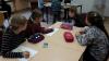4 Kinder sitzen am Tisch und malen
