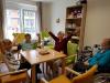 eine Sch&uuml;lerin, ein Sch&uuml;ler und 2 &auml;ltere Damen beim Spielen eines Gesellschaftsspiels
