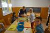 eine Sch&uuml;lerin, 2 Sch&uuml;ler und eine Lehrerin beim Schneiden von &Auml;pfeln