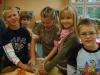 Lukas, Gina, Emmelie und Lars kneten einen Brotteig