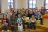 Die Kinder der 3. Klasse der Grundschule Röslau zeigen ihre gerade ausgeliehenen Bücher. Mit auf dem Bild Frau Gebhardt, die ehrenamtlich die Ortsbücherei verwaltet.