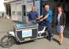 Markus Röder (links) und Bernd Schickling von der Beckl Karosserie + Lack GmbH & Co. KG in Maintal führen Wirtschaftsförderin Anke Prätzas das neue E-Lastenrad vor.  Foto: Stadt Maintal